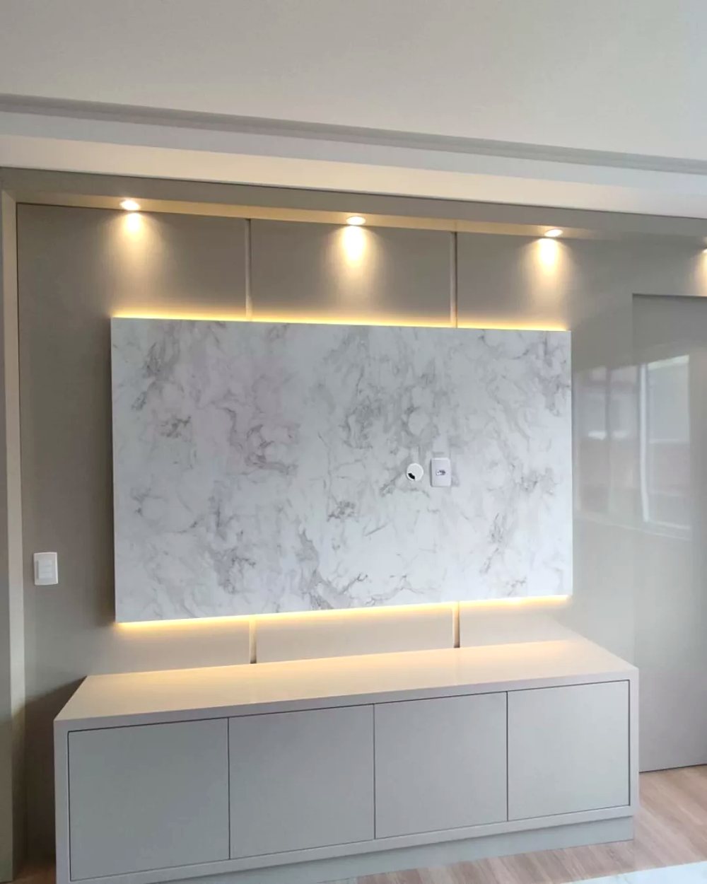 Painel de TV em mármore com rack branco e luz indireta — Marcenaria Costa, Curitiba